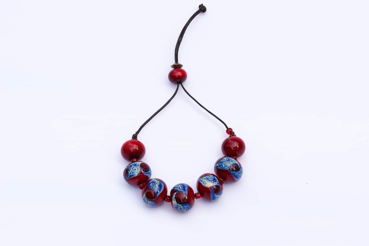 "Blue Swirls in a Cherry Sea" Bracelet Shop by Venezia Autentica - Shop by Venezia Autentica - Stunning Murano Glass bracelet, handmade in Venice, with mesmerizing red and blue beads. Every bead, crafted by lampworking, is unique, beautiful, and durable.